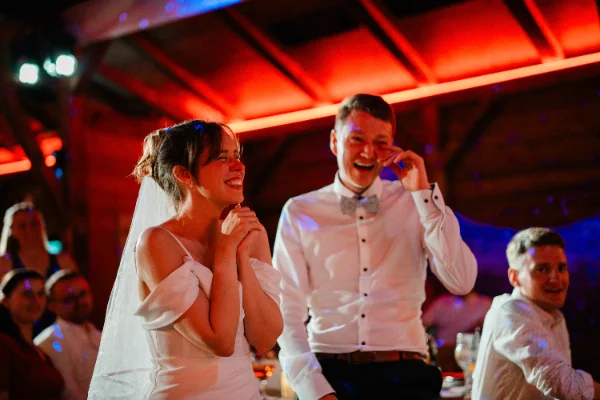 Braut und Bräutigam lachen Tränen auf der Party im roten Licht
